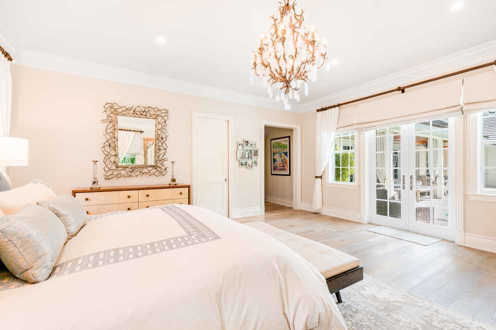 1230 North Ocean Boulevard Gulf Stream, FL 33483 - Photo 19 of 53 a spacious bedroom with a large bed and a chandelier