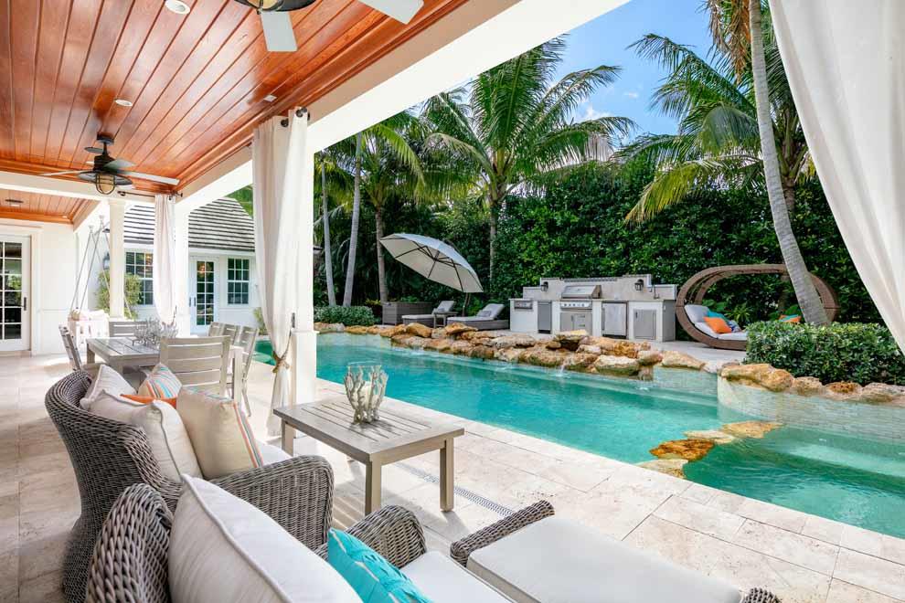 1230 North Ocean Boulevard Gulf Stream, FL 33483 - Photo 41 of 53 a view of a patio with couches table and chairs potted plants and palm trees