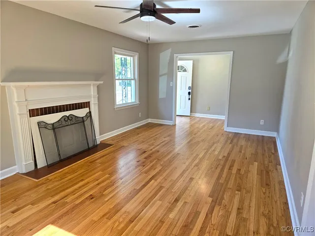 a view of a livingroom with wooden floor and a fireplace