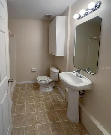 a bathroom with a sink toilet and a mirror