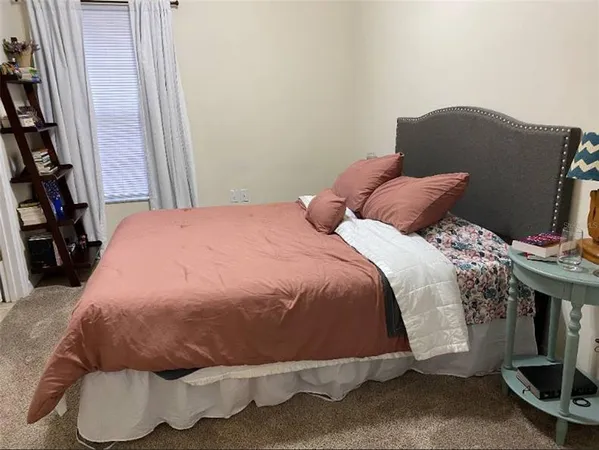 a bed sitting in a bedroom next to a window