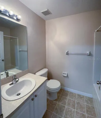 a bathroom with a sink toilet and a mirror