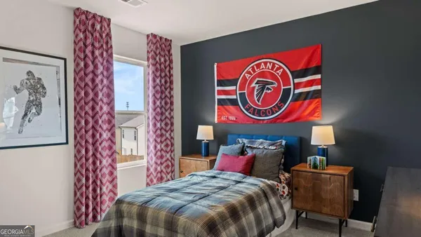 a bedroom with a bed and a painting on the wall