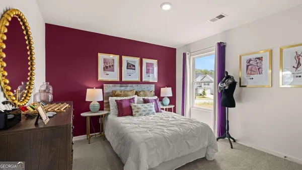 a bedroom with a bed and a potted plant