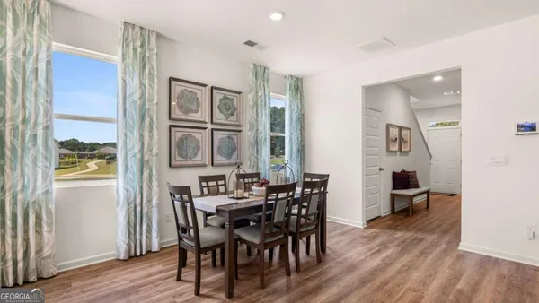 a view of a dining room with furniture and wooden floor