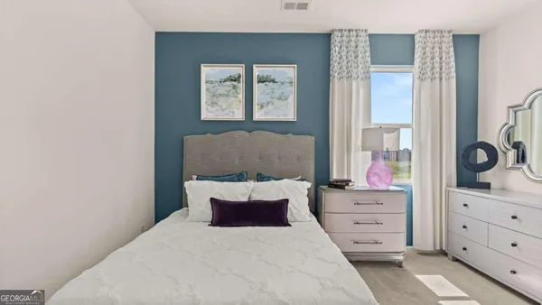 a bedroom with a bed and a dresser