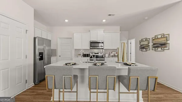 a kitchen with stainless steel appliances granite countertop a dining table and chairs