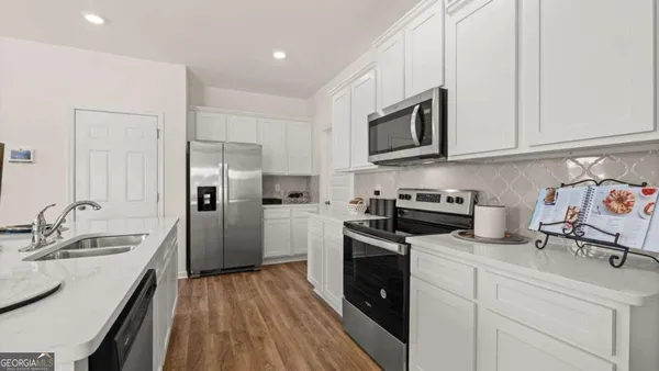 a kitchen with stainless steel appliances a stove sink and microwave
