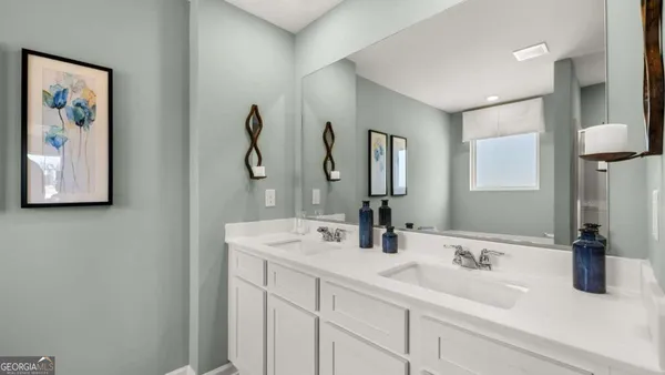 a bathroom with double vanity sink and a mirror