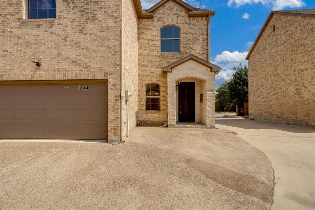 12364 Halima Street Dallas, TX 75243 - Photo 1 of 30 Brick exterior with stone accents, arched windows, and an integrated garage