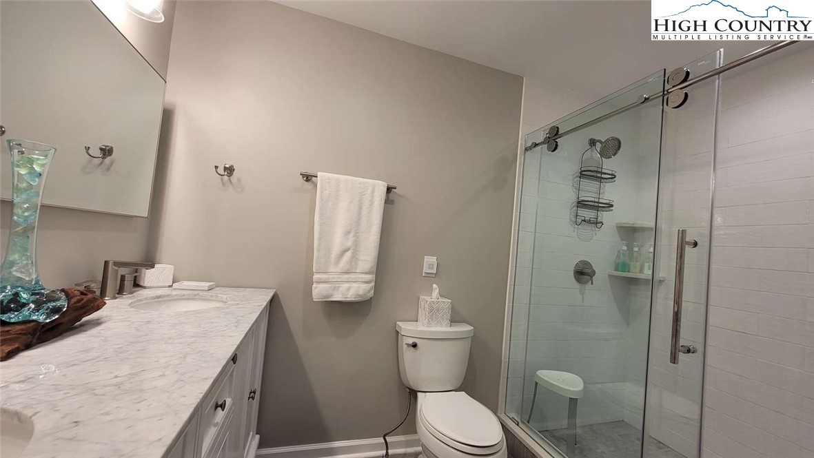 1157 Pine Ridge Road Beech Mountain, NC 28604 - Photo 13 of 25 a bathroom with a granite countertop sink toilet and shower