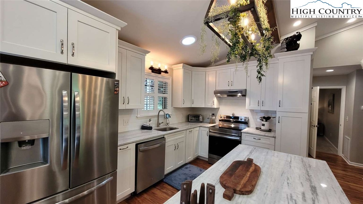 1157 Pine Ridge Road Beech Mountain, NC 28604 - Photo 3 of 25 a kitchen with a refrigerator a sink and cabinets