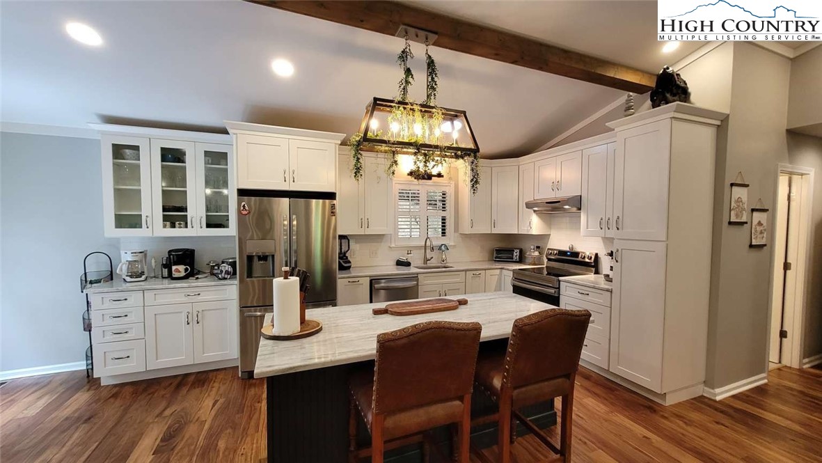 1157 Pine Ridge Road Beech Mountain, NC 28604 - Photo 10 of 25 a kitchen with stainless steel appliances a dining table chairs stove refrigerator and cabinets