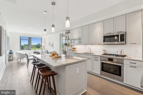 a kitchen with a stove a sink a dining table and chairs