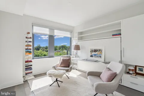 a living room with furniture and a floor to ceiling window