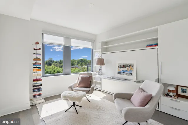 a living room with furniture and a floor to ceiling window