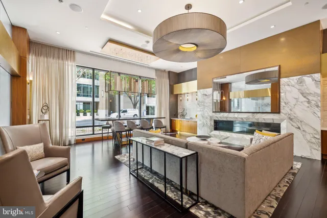 a room with stainless steel appliances kitchen island granite countertop a stove and a living room view