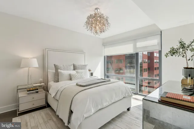 a bedroom with a large bed and a chandelier
