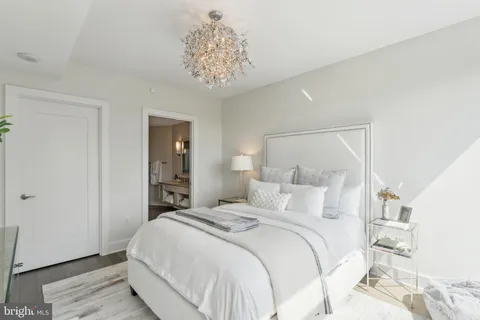 a bedroom with a large bed and a chandelier
