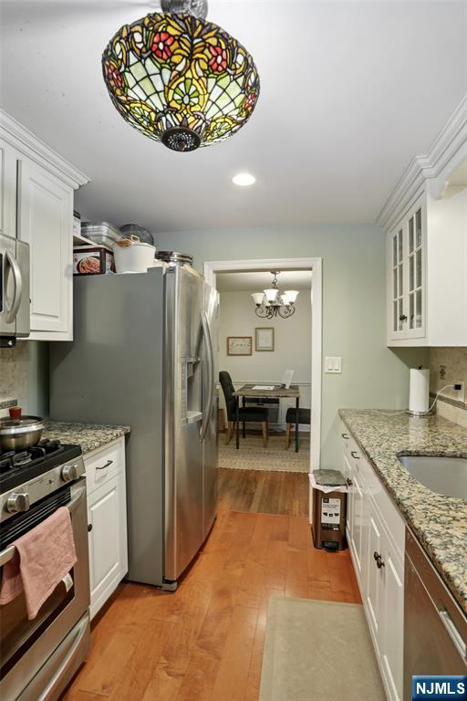 322 Marshall Street Ridgewood, NJ 07450 - Photo 15 of 32 a kitchen with a refrigerator and a stove top oven