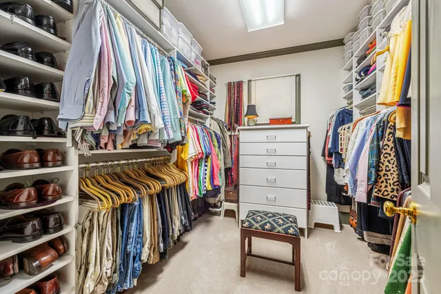a view of walk in closet with clothes and shoes