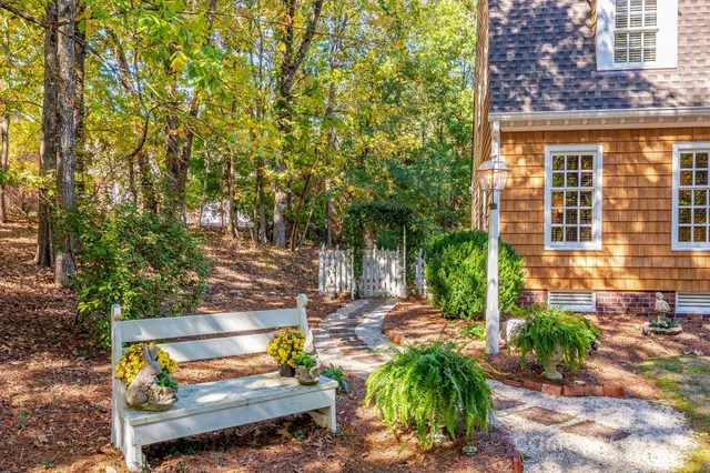a view of a house with backyard and trees