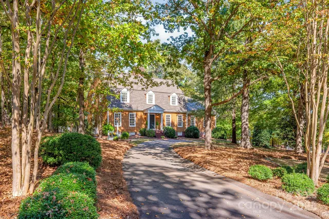 an aerial view of residential house with outdoor space and trees all around