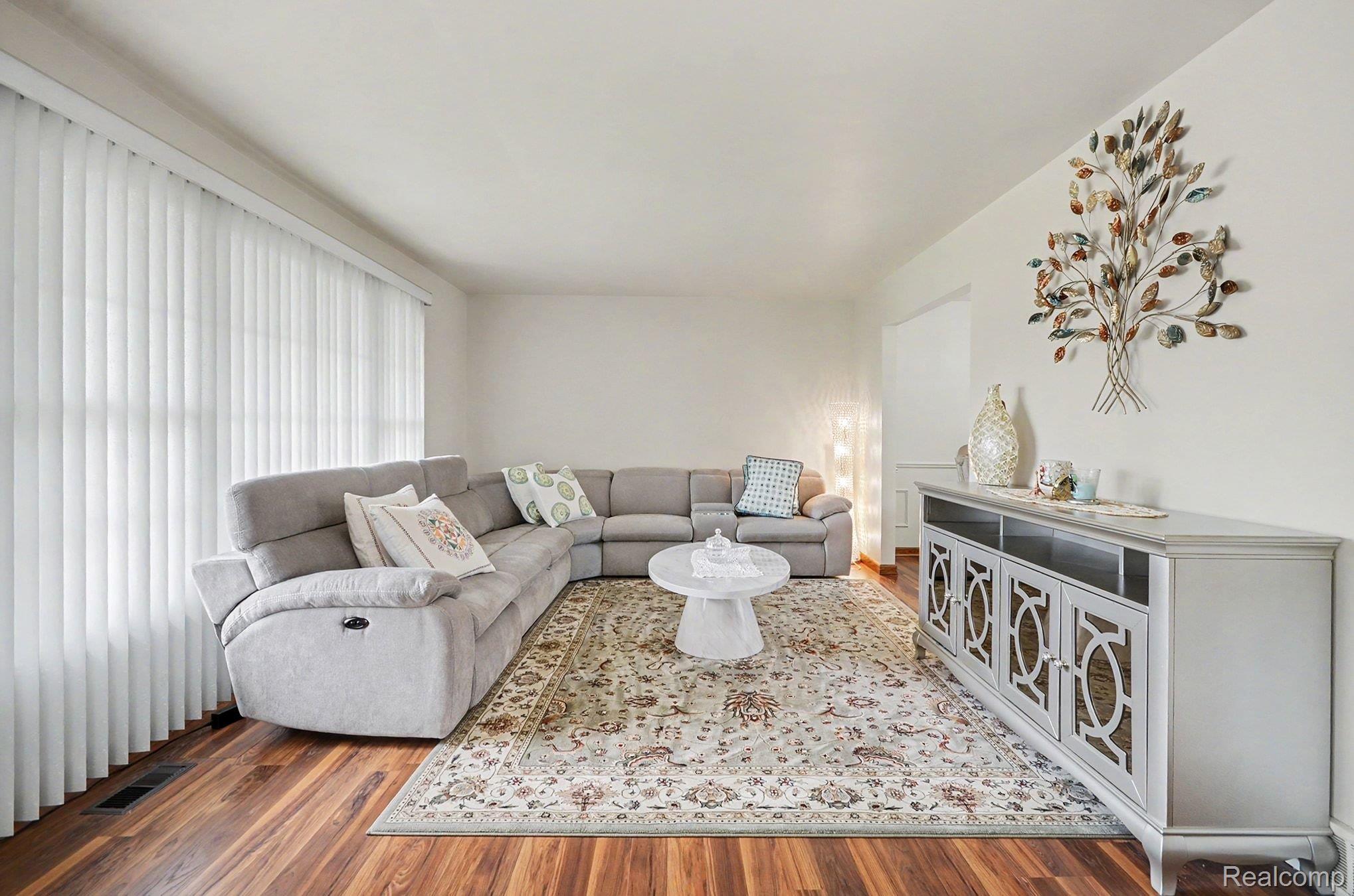 6653 Flintlock Ridge Utica, MI 48317 - Photo 6 of 31 Spacious living area featuring wood-finish flooring, ample natural light from extensive window treatments, and a decorative wall niche