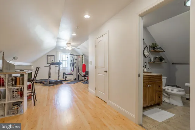 a view of a living room and bathroom with a wooden floor