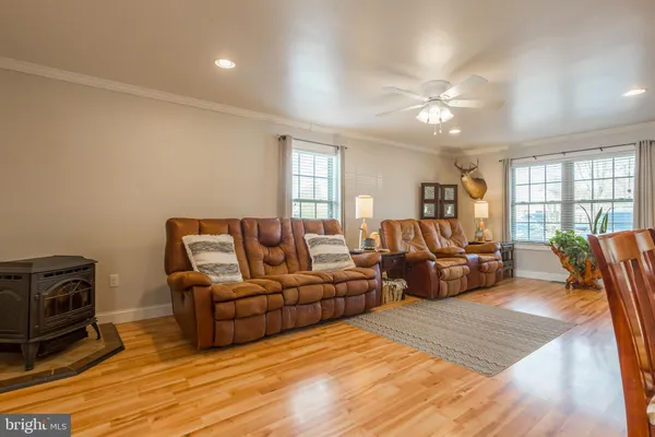 a kitchen with stainless steel appliances granite countertop a refrigerator a stove a sink a dining table and chairs with wooden floor