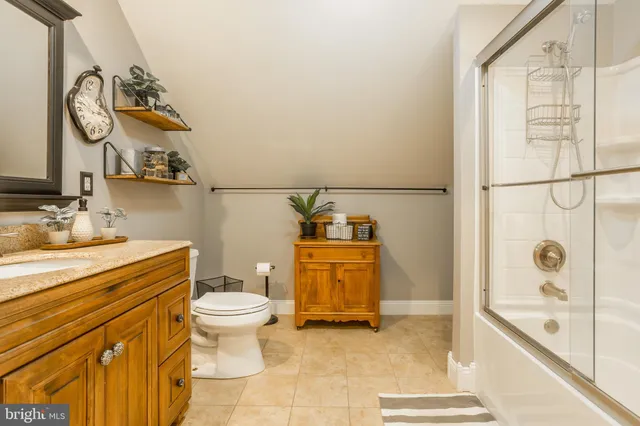 a view of a living room and bathroom with a wooden floor