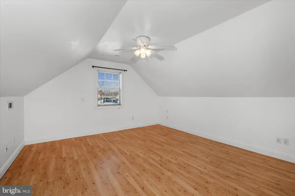 a view of an empty room with chandelier fan