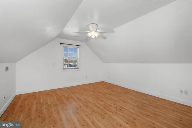 a view of an empty room with chandelier fan