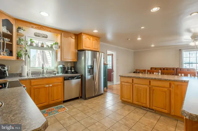 a large kitchen with stainless steel appliances granite countertop a refrigerator and a sink
