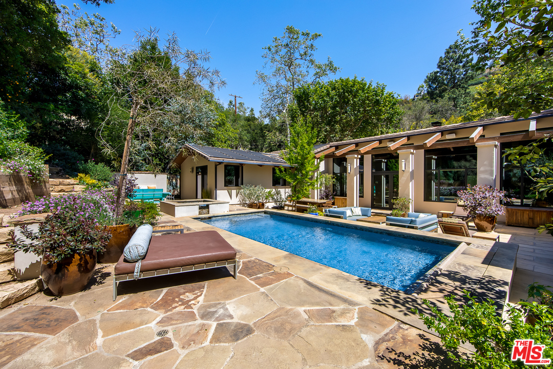 1787 Old Ranch Road Los Angeles, CA 90049 - Photo 1 of 54 a view of a patio with table and chairs potted plants and large tree