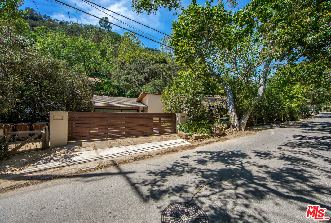 1787 Old Ranch Road Los Angeles, CA 90049 - Photo 2 of 54 a view of a yard with plants and large trees