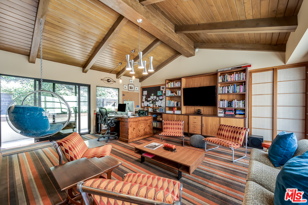 1787 Old Ranch Road Los Angeles, CA 90049 - Photo 42 of 54 a living room with furniture a flat screen tv and a floor to ceiling window