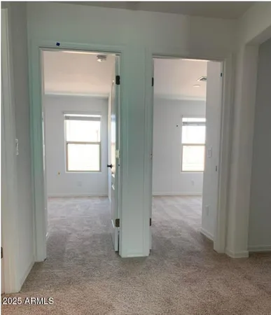 a view of an empty room with closet and a window