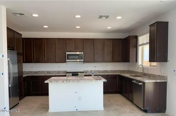 a kitchen with a sink and a stove top oven with wooden cabinets