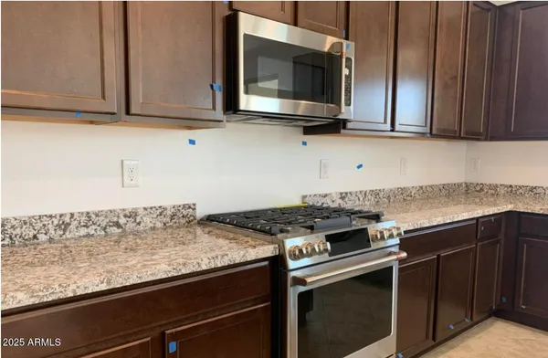 a kitchen with stainless steel appliances granite countertop a stove and a microwave