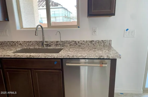 a view of a kitchen sink granite counter tops and a window