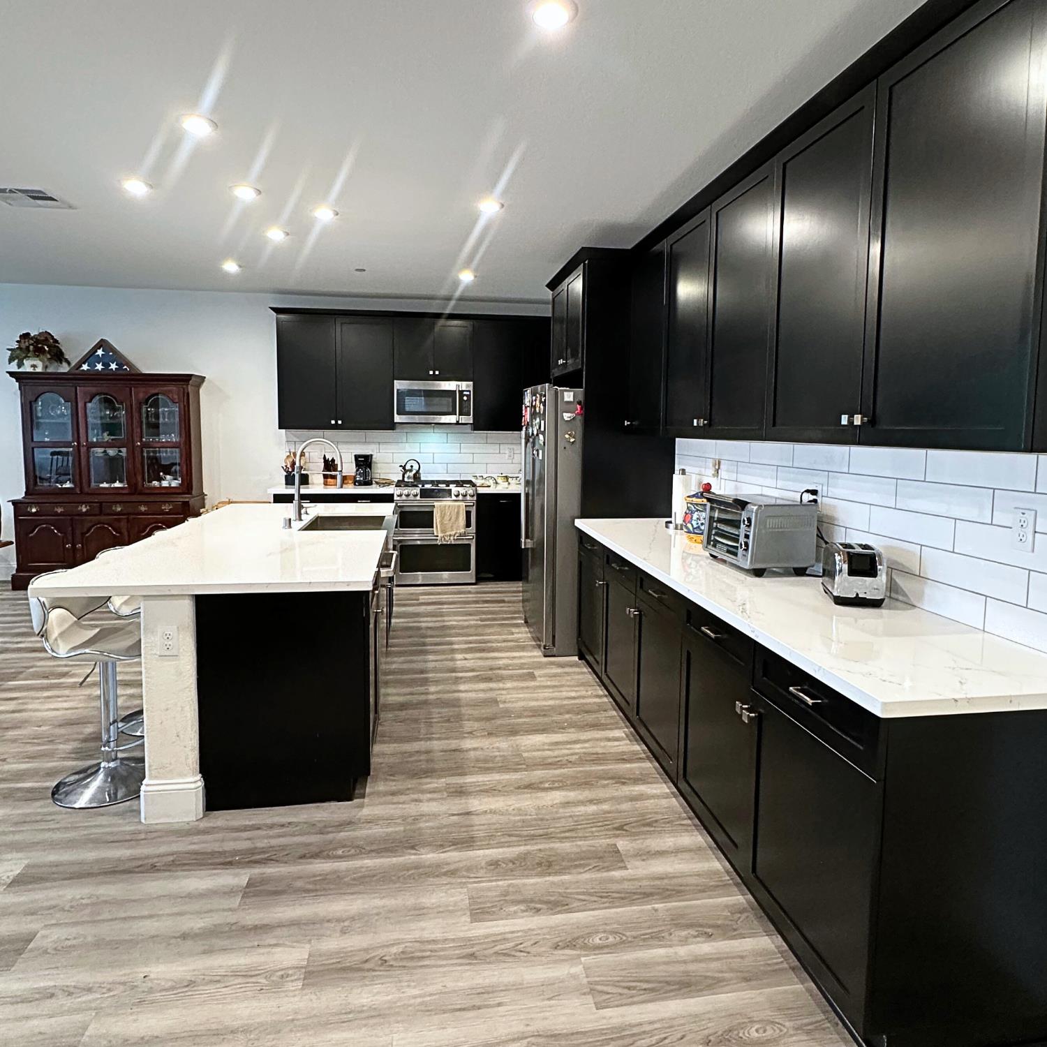 10113 Wayfaring Drive Stockton, CA 95219 - Photo 11 of 26 a large kitchen with stainless steel appliances a sink a stove and cabinets