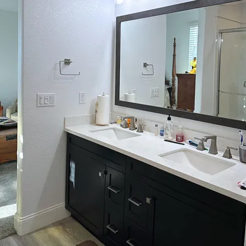 a en suite bathroom with a sink a mirror and shower