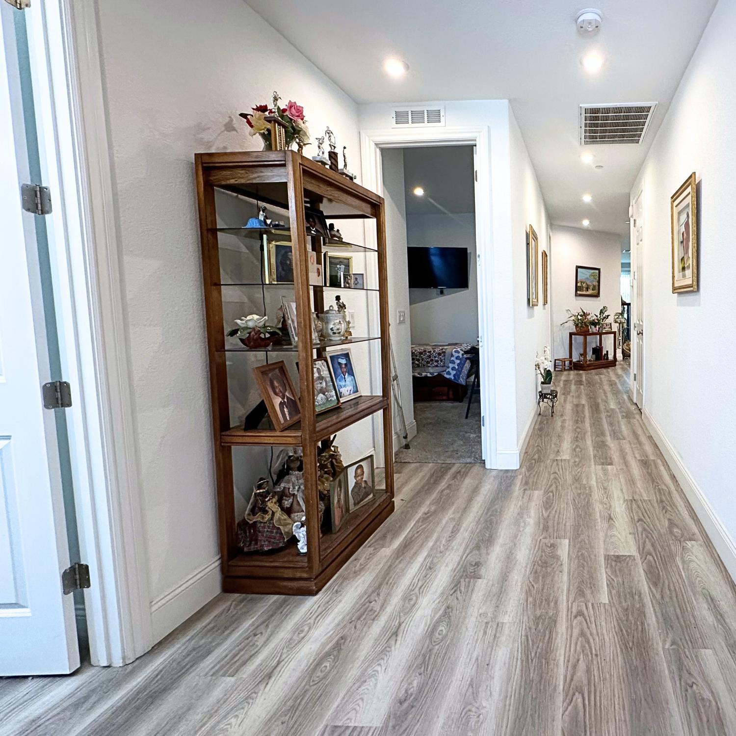 10113 Wayfaring Drive Stockton, CA 95219 - Photo 4 of 26 a view of a hallway with wooden floor and a living room