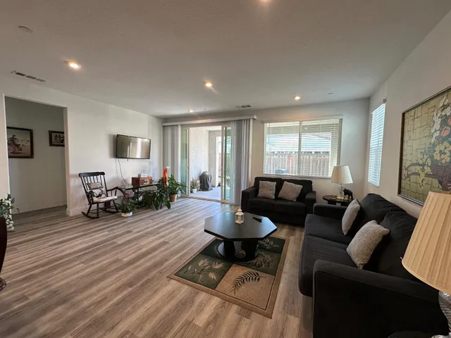a living room with furniture and a wooden floor