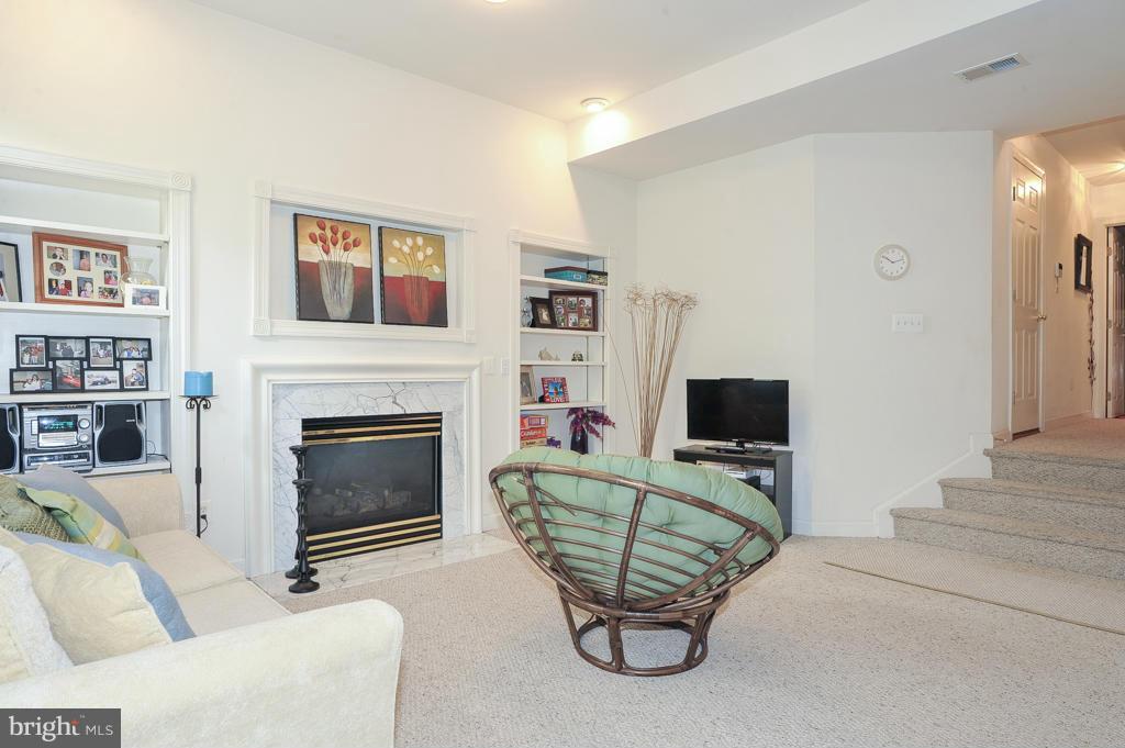 6625 Debra Lu Way Springfield, VA 22150 - Photo 21 of 26 a living room with furniture a flat screen tv and a fireplace