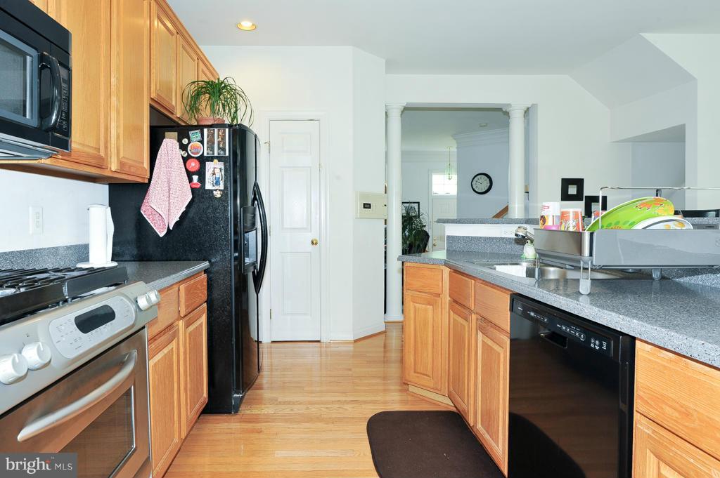 6625 Debra Lu Way Springfield, VA 22150 - Photo 8 of 26 a kitchen with stainless steel appliances granite countertop a sink a stove and a refrigerator