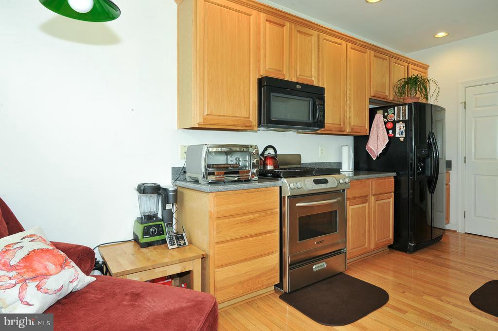 6625 Debra Lu Way Springfield, VA 22150 - Photo 9 of 26 a kitchen with stainless steel appliances granite countertop a stove a sink and a microwave