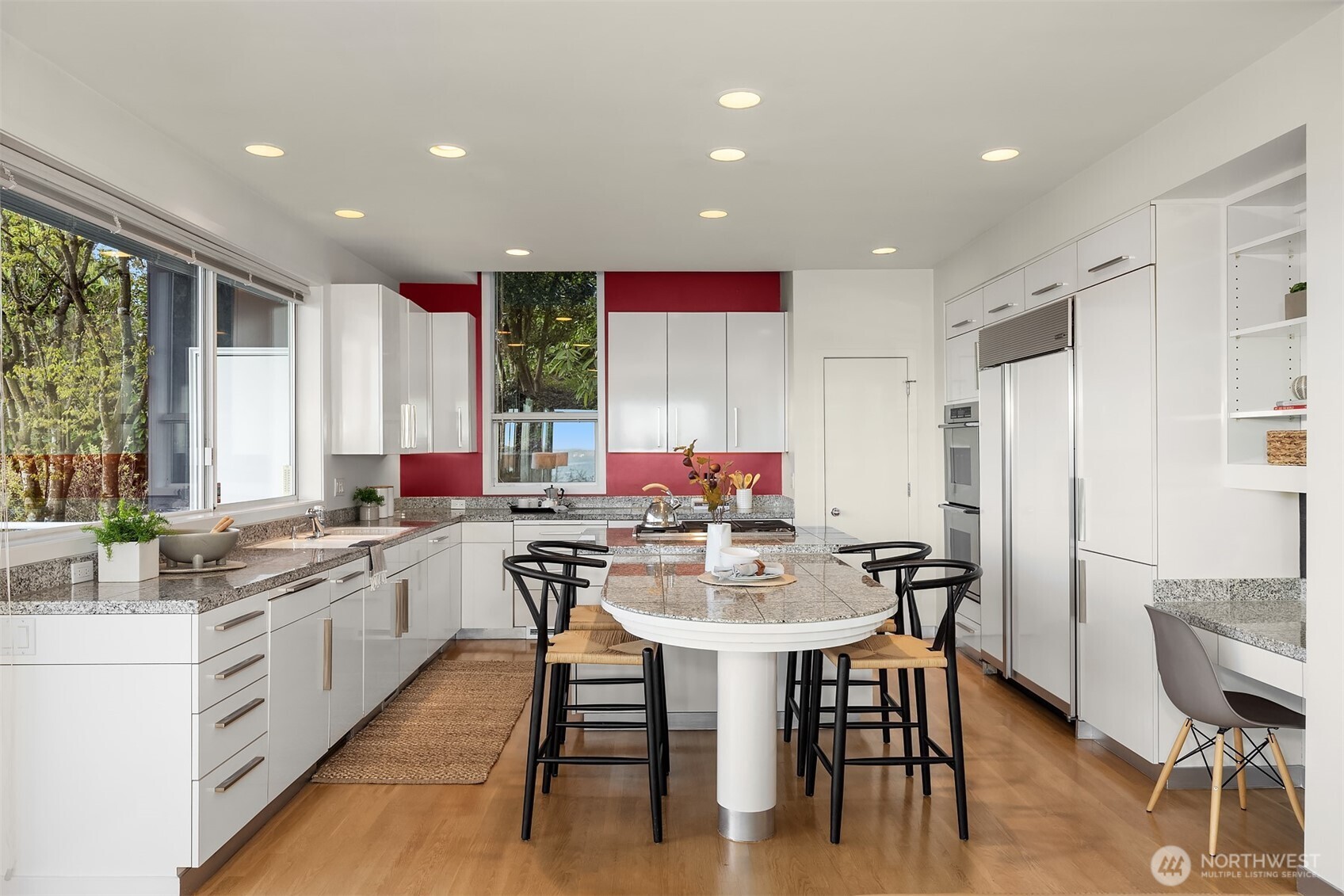 3903 48th Avenue South Seattle, WA 98118 - Photo 23 of 40 a kitchen with stainless steel appliances granite countertop a stove top oven a sink dishwasher a dining table and chairs with wooden floor