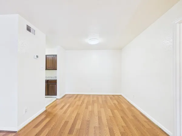 a view of a big room with wooden floor and entryway